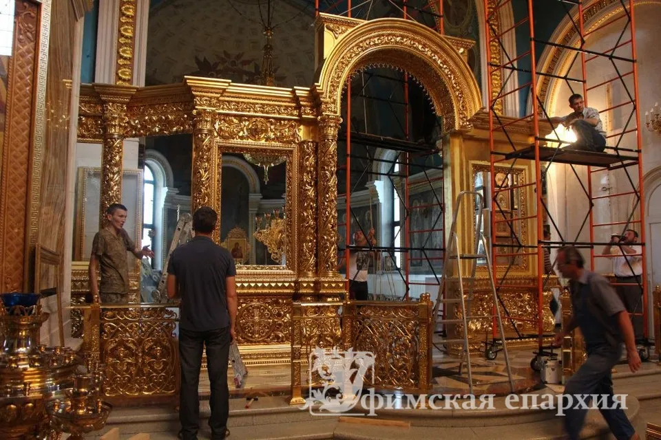 Рабочие на лесах монтируют золочёный иконостас собора