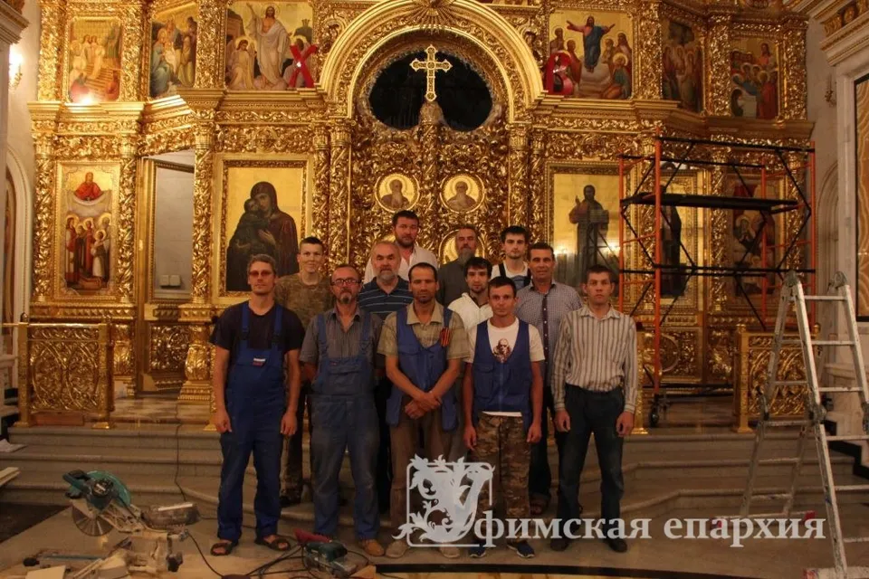 Группа мастеров-резчиков на фоне нового золочёного иконостаса